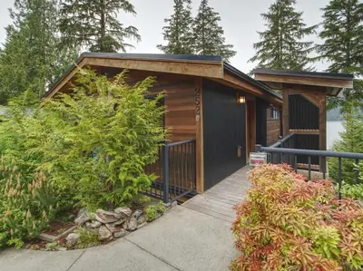 a small cabin with a wooden walkway in a garden at Going Coastal AB - Oceanfront - Pet Friendly in Port Renfrew