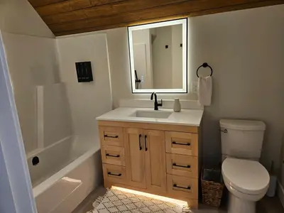 a bathroom with a sink and a toilet and a mirror at Hot Tub - Sleep 12 - EV Charger J1772 - Forest View - Pet Friendly in Mount Washington