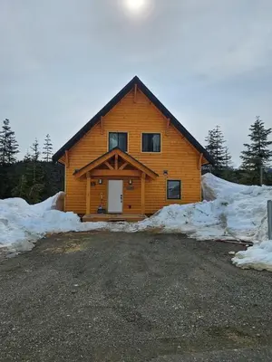 a large wooden cabin with snow around it at Hot Tub - Sleep 12 - EV Charger J1772 - Forest View - Pet Friendly in Mount Washington
