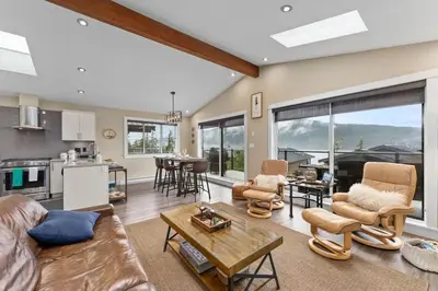 a living room with a couch and a table at Spacious Oceanview - 2 living rooms & fridges - Pet Friendly in Port Renfrew