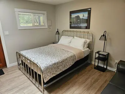 a bed with a metal frame in a bedroom at Cozy Rainforest Cottage for 2 - Pet Friendly in Port Renfrew