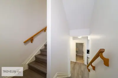a staircase in a home with white walls and wood floors at Spacious Private Apartment with King Bed, Full Kitchen and In-Suite Laundry in Edmonton