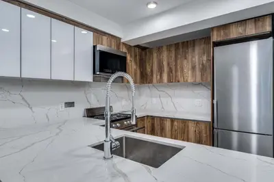 a kitchen with a sink and a stainless steel refrigerator at Prime West End 2BR- Central Vancouver Lifestyle in Vancouver