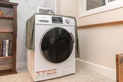 a washing machine sitting next to a wall at 2 Bedroom 1 Bath On An Oak Tree Lined End Street On The Galloping Goose in Victoria