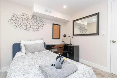 a bedroom with a bed and a desk and a mirror at 2 Bedroom 1 Bath On An Oak Tree Lined End Street On The Galloping Goose in Victoria
