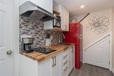 a kitchen with white cabinets and a red refrigerator at 2 Bedroom 1 Bath On An Oak Tree Lined End Street On The Galloping Goose in Victoria