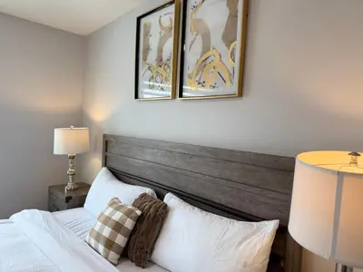 a bedroom with a bed and two pictures on the wall at Family Friendly GarageFireplace Sleeps 8 in Edmonton