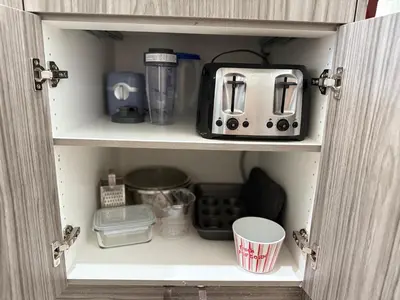 a cupboard with a toaster and other kitchen items at Family Friendly GarageFireplace Sleeps 8 in Edmonton