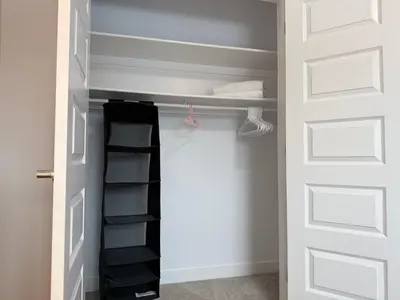 a closet with a white door and a black shelf at Family Friendly GarageFireplace Sleeps 8 in Edmonton