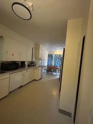a kitchen with white cabinets and a dining room at Vancouver Budget Stay - Airport 10 Min - Free Parking & Fast WiFi in Vancouver
