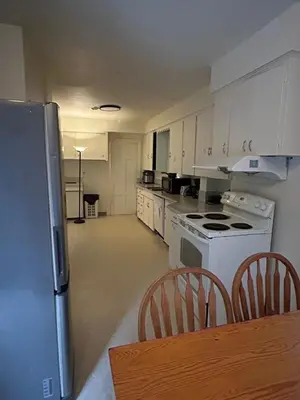 a kitchen with white appliances and a table and chairs at Budget Vancouver Stay - Airport & Downtown 10 & 15 Min, Free Parking & Fast Wifi in Vancouver