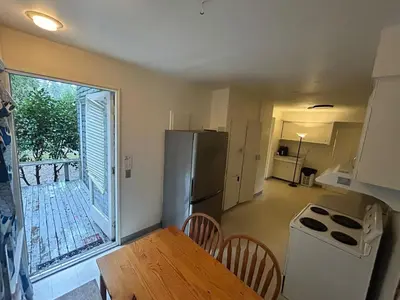 a kitchen with a refrigerator and a table with chairs at Budget Vancouver Stay - Airport & Downtown 10 & 15 Min, Free Parking & Fast Wifi in Vancouver