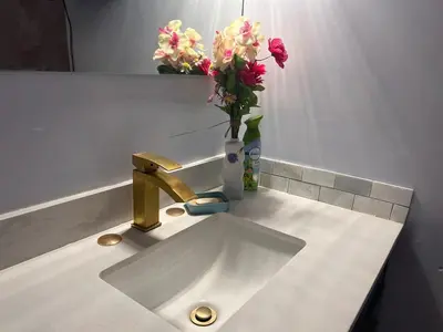 a bathroom sink with a vase of flowers on it at Cozy home in Calgary