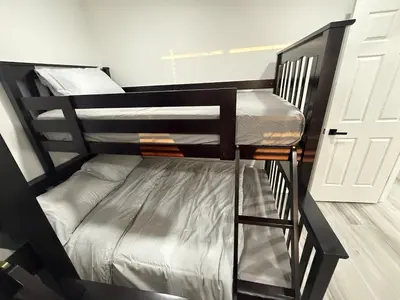 a black bunk bed in a room with a door at Family-Friendly Home in the Heart of Chestermere in Chestermere