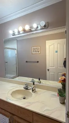 a bathroom with a sink and a large mirror at North Delta Budget Stay - Scott Road - Free Parking & Fast WiFi in Delta