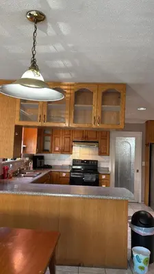 a large kitchen with wooden cabinets and aendant light at North Delta Budget Stay - Scott Road - Free Parking & Fast WiFi in Delta