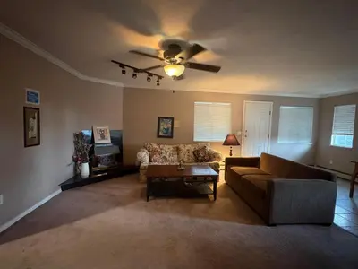 a living room with a couch and a ceiling fan at Budget Stay Near Scott Road - Transit, Free Parking & Fast WiFi in Delta