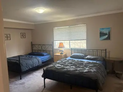 a bedroom with two beds and a window at Budget Stay Near Scott Road - Transit, Free Parking & Fast WiFi in Delta