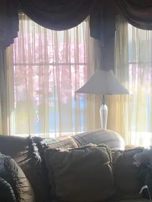 a bedroom with a couch and a lamp in front of a window at Harmony House short term rental in Okotoks