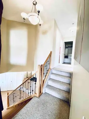 a staircase in a home with a chandelier at Spacious 3BR Retreat w-Hot Tub Ravine Sleeps 9 in Edmonton