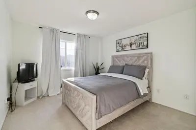 a bedroom with a large bed and a tv at Renovated Cozy Family Home Spacious, Modern in Edmonton