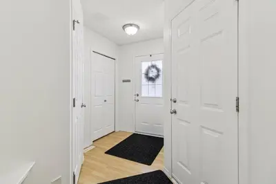 a hallway with white doors and a rug at Renovated Cozy Family Home Spacious, Modern in Edmonton