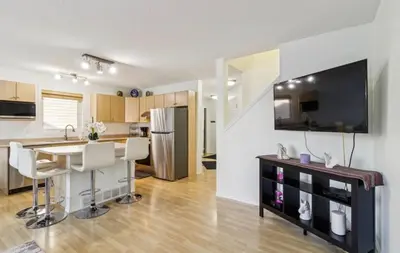 a kitchen and living room with a table and a counter at Renovated Cozy Family Home Spacious, Modern in Edmonton