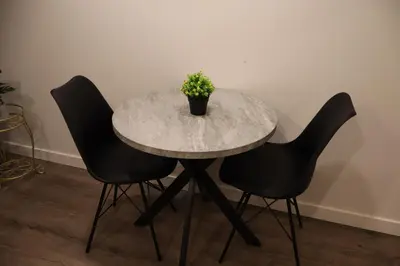 a marble table with two chairs and a potted plant at Cozy and Private Guest Suite in West Edmonton in Edmonton
