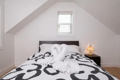 a bedroom with a bed with a black and white comforter at Private 2BR 2Bath Suite - Sunset Vancouver in Vancouver