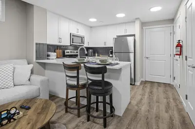 a kitchen with a counter and two bar stools at Private Guest Suite in SE Calgary 5 minutes to South Health Campus & Seton YMCA in Calgary