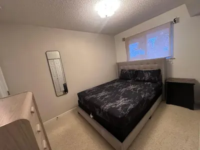 a small bedroom with a bed and a window at 3 Private rooms with built-in closet & desk in Edmonton