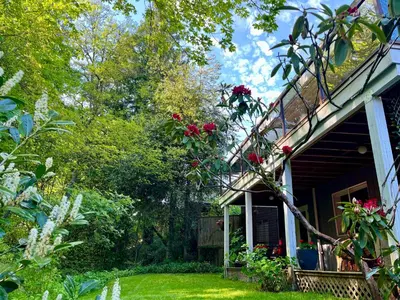 a house with flowers on the side of it at Lynn Canyon Forest Retreat in North Vancouver