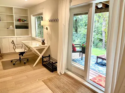 a home office with a desk and a sliding glass door at Lynn Canyon Forest Retreat in North Vancouver