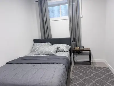 a bed sitting in a bedroom with a window at The Cozy Spot in Edmonton