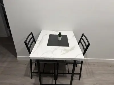 a white table with two chairs and a potted plant on it at The Cozy Spot in Edmonton