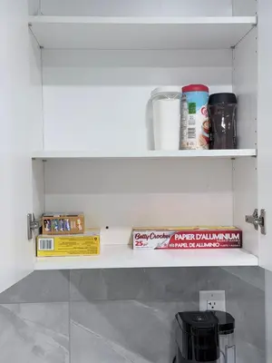 a shelf with books and other items in a kitchen at The Cozy Spot in Edmonton