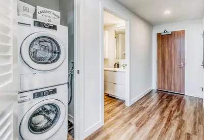 a laundry room with two washer and dryer at Simple Minimalist Condo For Busy Students or Professionals in Calgary