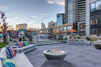 a patio with couches and a fire pit in a city at Simple Minimalist Condo For Busy Students or Professionals in Calgary