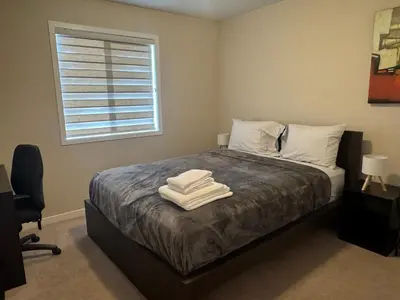 a bedroom with a bed with two towels on it at Peace Home in Calgary