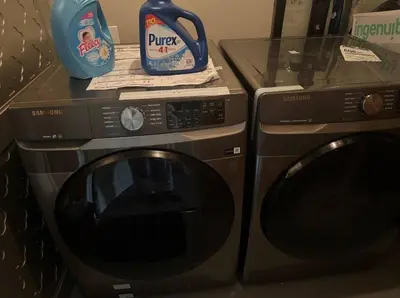 a microwave and a washing machine next to each other at Quiet Comfortable 1-Bedroom in Calgary
