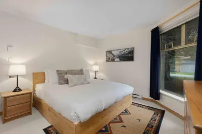 a bedroom with a bed and a large window at Glen Eagles by Whistler Premier in Whistler
