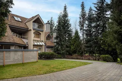 a large house with a fence and a driveway at Glen Eagles by Whistler Premier in Whistler