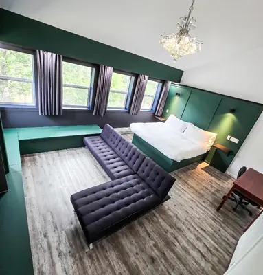 a living room with a couch and a bed and a table at Copper Rose Retreat - Mountain B&B in Invermere