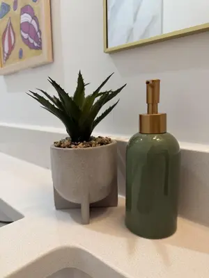 a bottle of soap and a plant on a bathroom sink at Private 2BR Lake Suite - Chestermere - Sleeps 6 in Chestermere
