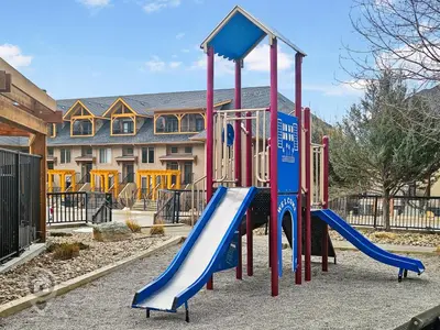 a playground with a slide in front of a house at Bighorn Meadows Condos by StayIn in Radium Hot Springs