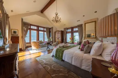 a bedroom with a large bed in a room with windows at Chateau Okanagan in Kelowna