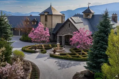 a home with a garden with pink trees and a church at Chateau Okanagan in Kelowna