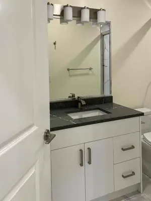 a white bathroom with a sink and a mirror at SixPine - One bedroom suite in Vancouver