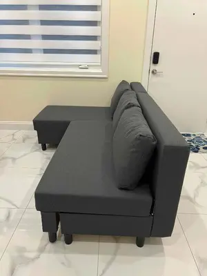 a black couch sitting in a living room at SixPine - One bedroom suite in Vancouver