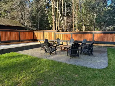 a patio with chairs and tables in a yard at Large ocean view family retreat in Comox
